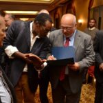 A parent getting his daughter's photograph autographed by President Donald Ramotar